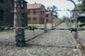 Concentration camp Auschwitz, Oswiecim. Barbed wire fence with barrack on background. Holocaust memorial.