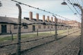 Concentration camp Auschwitz, Oswiecim. Barbed wire fence with barrack on background. Holocaust memorial. Royalty Free Stock Photo