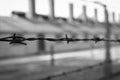 Concentration camp Auschwitz, Oswiecim, monochrome. Barbed wire fence with barrack on background. Holocaust memorial Royalty Free Stock Photo