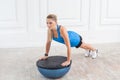 Concentration sporty beautiful young athletic blonde woman in black shorts and blue top working in gym doing plank for abdominal Royalty Free Stock Photo