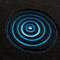 Concentric circles are carved into a rough, dark surface, emitting a blue glow from Royalty Free Stock Photo