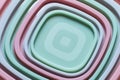 Concentric composition of square plastic food container caps. Pastel colors background Royalty Free Stock Photo