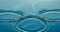 Concentric ripple patterns form on a calm, blue water surface, creating a series of intersecting Royalty Free Stock Photo
