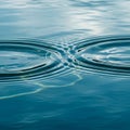 Concentric ripples disturb the surface of calm, blue water, creating a layered, Royalty Free Stock Photo