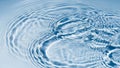 Rippling blue water surface with concentric circles and light reflections creating a serene and calming abstract Royalty Free Stock Photo