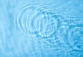 Concentric waves on blue water surface after falling drops, top Royalty Free Stock Photo