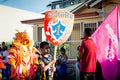 Closeup boys carry emblem and flag of group on city street at dominican carnival