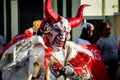 Closeup man in red and white devil costume passes by city street at dominican carnival Royalty Free Stock Photo