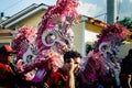 Closeup persons in brilliant carnival costumes pass by dominican city street