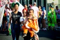 Family in colorful costumes pass on city street at dominican annual carnival