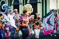 Many people carry variegated flags passing by city street at dominican carnival