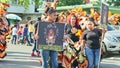 People in colorific masquerade costumes walk on city street at dominican carnival