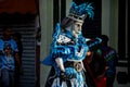 Person in bright masquerade costume walks by city street at dominican carnival