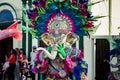 Person puts on heavy motley elephant mask on city street at dominican carnival