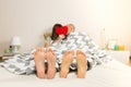 Young couple kisses in bed in minimalistic modern bedroom