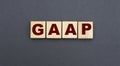 Concept acronym GAAP on wooden cubes on a gray background