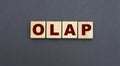 Concept acronym OLAP on wooden cubes on a gray background