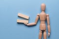 The concept of additional tasks. Wooden blocks holds a mannequin on a blue background