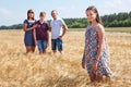 Concept of adopted child, young girl standing on foreground with adoptive family on background, stepdaughter with father, mother