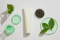 Advertising scene with a bottle mockup for cosmetic with green tea leaves on beige background Royalty Free Stock Photo