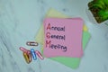 Concept of AGM - Annual General Meeting write on sticky notes isolated on Wooden Table