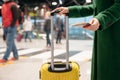 Concept airplane travel in autumn. Faceless woman in green coat holds passport with ticket and yellow suitcase airport Royalty Free Stock Photo
