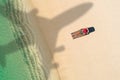 Concept of airplane travel to exotic destination with shadow of commercial airplane flying above beautiful tropical beach. Beach Royalty Free Stock Photo