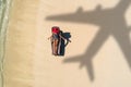 Concept of airplane travel to exotic destination with shadow of commercial airplane flying above beautiful tropical beach. Beach Royalty Free Stock Photo