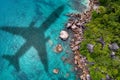 Concept of airplane travel to exotic destination with shadow of commercial airplane flying above beautiful tropical beach. Beach Royalty Free Stock Photo