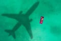 Concept of airplane travel to exotic destination with shadow of commercial airplane flying above beautiful tropical beach. Beach Royalty Free Stock Photo