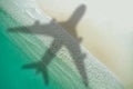 Concept of airplane travel to exotic destination with shadow of commercial airplane flying above beautiful tropical beach. Beach Royalty Free Stock Photo