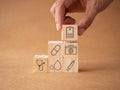 Concept annual health check-up. Hand holding wooden cubes with healthcare medical icons report, blood, syringe, stethoscope, and h Royalty Free Stock Photo