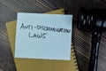 Concept of Anti-Discrimination Laws write on sticky notes with gavel isolated on Wooden Table