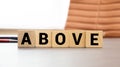 Concept of antonym above and below on wooden blocks