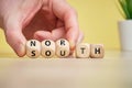 Concept of antonym North and South on wooden blocks