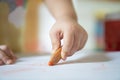 Close up hand of 2year kid use color pencil draw line on paper. Royalty Free Stock Photo