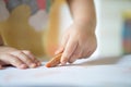 Close up hand of 2year kid use color pencil draw line on paper. Royalty Free Stock Photo