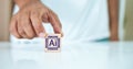 concept of Artificial Intelligence. Hand holding wooden block cube with AI icon. Machine with functions capable of understanding Royalty Free Stock Photo