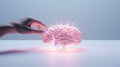 The concept of artificial intelligence. The hand presses the button. An abstract button designed as a glowing pink brain. Turn on