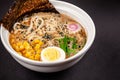 Concept of Asian cuisine. Ramen soup with Chinese noodles, egg, corn, green onions and fish seasoning in Japanese or Chinese dish Royalty Free Stock Photo