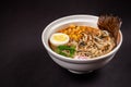 Concept of Asian cuisine. Ramen soup with Chinese noodles, egg, corn, green onions and fish seasoning in Japanese or Chinese dish Royalty Free Stock Photo