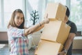 Concept young couple moving house. Asian woman helping man carry cardboard box to move in new house Royalty Free Stock Photo