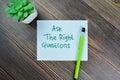 Concept of Ask The Right Questions write on sticky notes isolated on Wooden Table Royalty Free Stock Photo