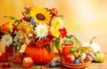 Concept of autumn festive decoration for Thanksgiving day. Autumn bouquet of flowers and berries in a pumpkin on a table, Royalty Free Stock Photo