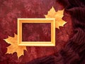 The concept of autumn. Maple leaves and text frame painted with gold paint on a background with a warm scarf. Royalty Free Stock Photo