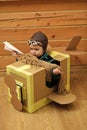 Concept of avia transportation. Little dreamer boy playing with a cardboard airplane. Royalty Free Stock Photo