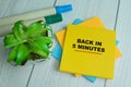 Concept of Back In 5 Minutes write on sticky notes isolated on Wooden Table