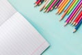 Concept back to school.School accessories, colored pencils, pen with empty notebook on blue wooden background Royalty Free Stock Photo