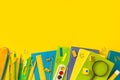 The concept of back to school. Colorful school supplies in blue, green on a yellow background. Books, notebooks, pens Royalty Free Stock Photo