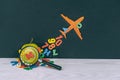 Concept Back to School. Flight of knowledge with airplane, green apple and colored letters on the background